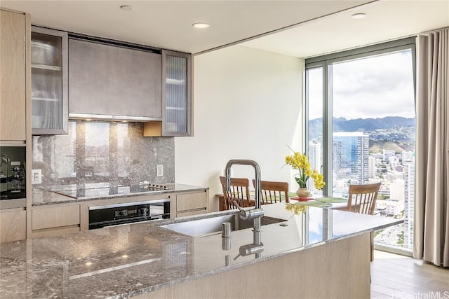 kitchen with black appliances, plenty of natural light, sink, and tasteful backsplash