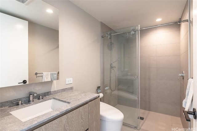 bathroom with tile patterned floors, vanity, toilet, and walk in shower