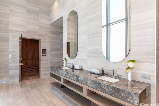 bathroom with vanity and tile walls