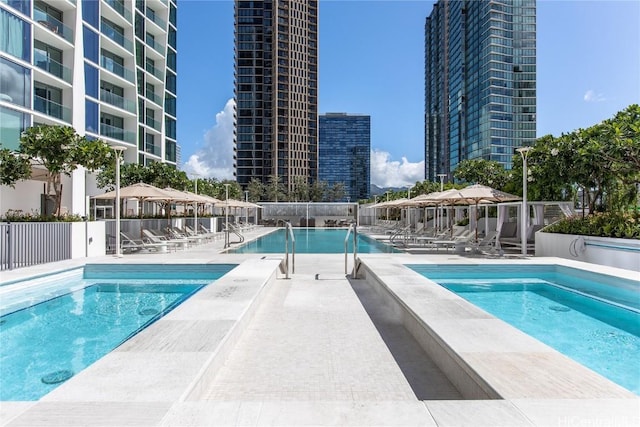 view of pool with a hot tub and a patio area