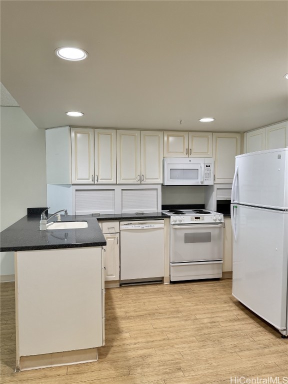 kitchen with kitchen peninsula, white appliances, sink, light hardwood / wood-style flooring, and white cabinetry