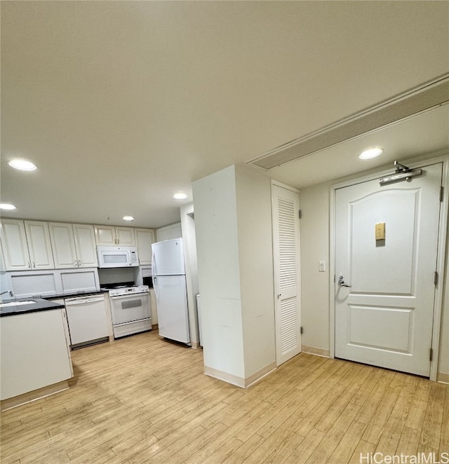 kitchen with light wood-type flooring, white appliances, white cabinets, and sink