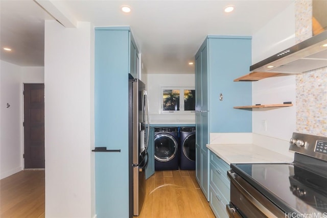 laundry room featuring washer and clothes dryer and light wood-type flooring