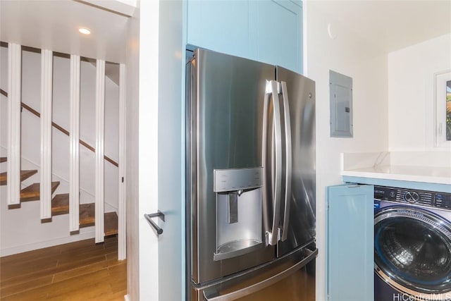 kitchen featuring washer / clothes dryer, blue cabinets, stainless steel fridge, hardwood / wood-style flooring, and electric panel