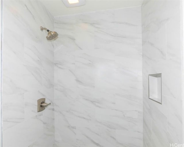 interior details with a tile shower