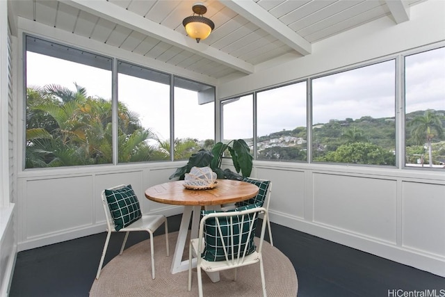 sunroom / solarium featuring beam ceiling and wooden ceiling