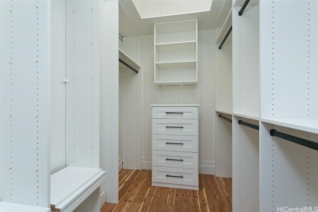 walk in closet with light hardwood / wood-style flooring