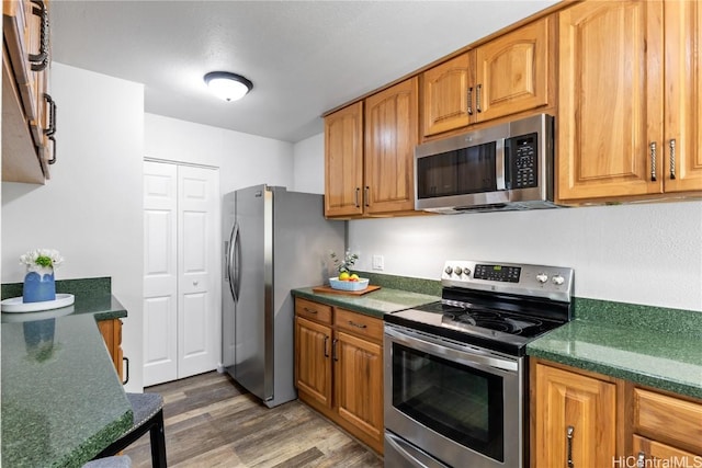 kitchen featuring stainless steel appliances and dark hardwood / wood-style floors