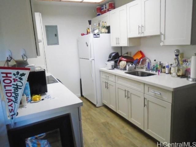 kitchen featuring light hardwood / wood-style floors, sink, white refrigerator, white cabinets, and electric panel