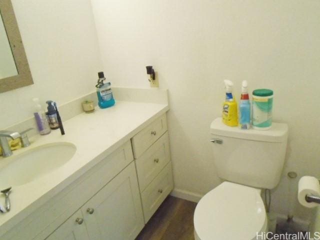 bathroom with hardwood / wood-style floors, vanity, and toilet