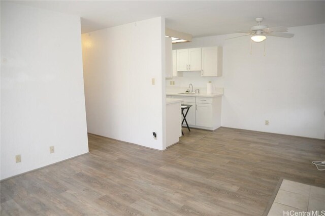 interior space featuring ceiling fan, a sink, and light wood-style flooring