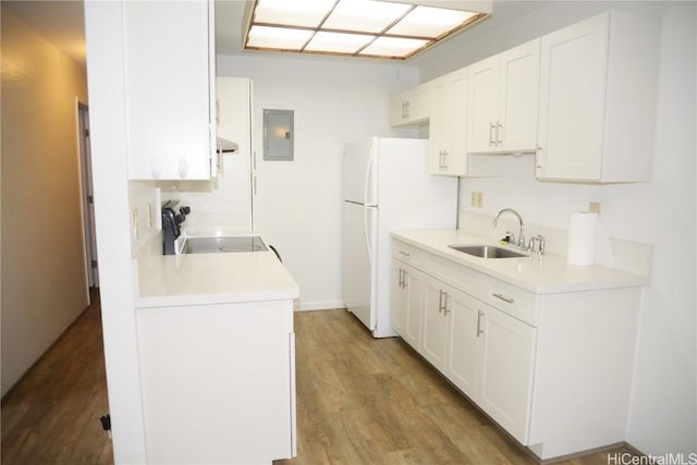 kitchen featuring freestanding refrigerator, light countertops, a sink, and stove