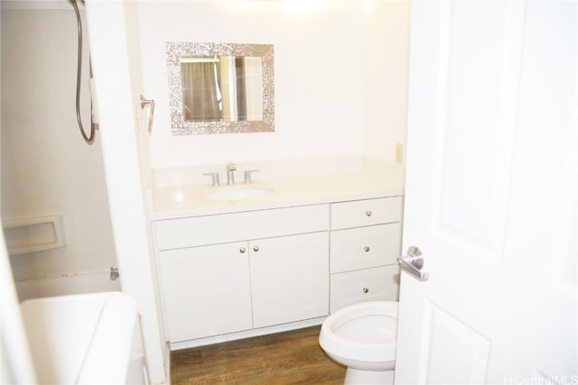 bathroom with toilet, shower / bathtub combination, wood finished floors, and vanity