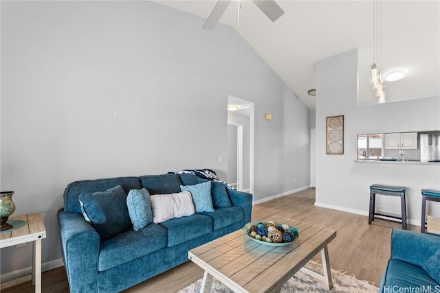 living room featuring ceiling fan, light wood-type flooring, and high vaulted ceiling