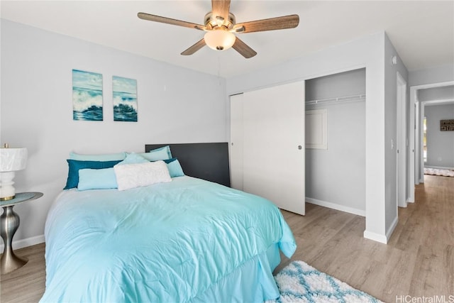 bedroom with ceiling fan, light wood-type flooring, and a closet