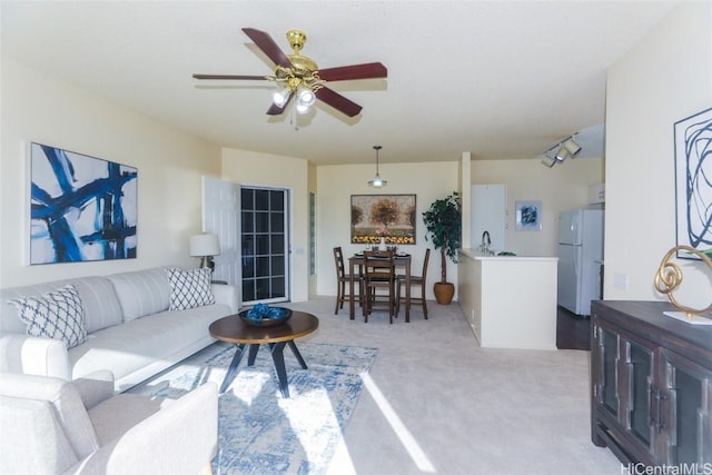 carpeted living room with ceiling fan