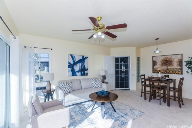 living room featuring ceiling fan, carpet, and a textured ceiling