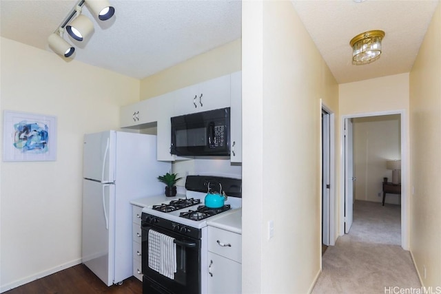 kitchen with white cabinets, carpet flooring, white appliances, and a textured ceiling