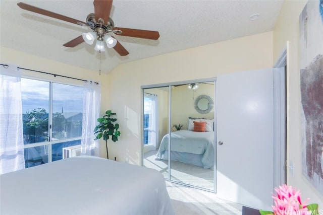 carpeted bedroom featuring ceiling fan, a textured ceiling, and a closet