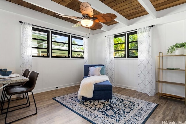 living area featuring beam ceiling, dark wood-type flooring, wood ceiling, and a healthy amount of sunlight