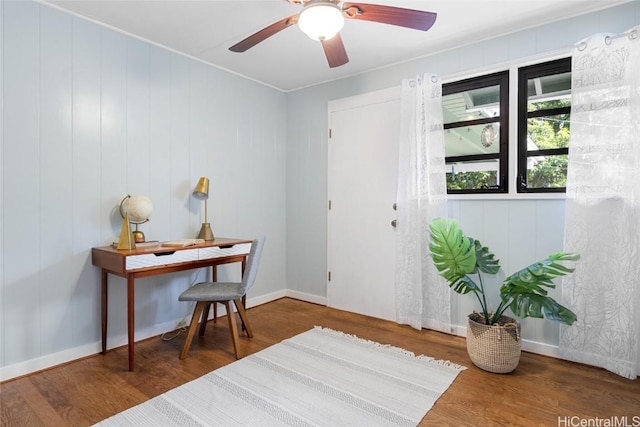 entrance foyer with hardwood / wood-style floors, ornamental molding, ceiling fan, and wooden walls