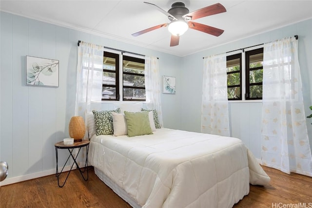 bedroom with multiple windows, dark wood-type flooring, and ceiling fan