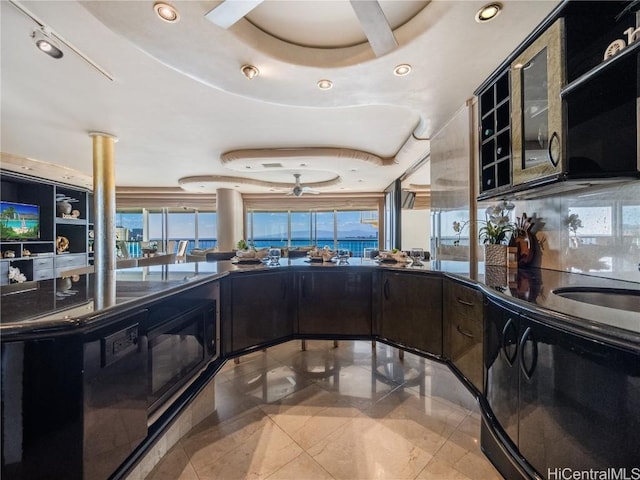 kitchen with a raised ceiling, decorative backsplash, and black appliances