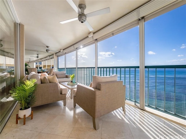 sunroom / solarium with ceiling fan, a water view, and a wealth of natural light