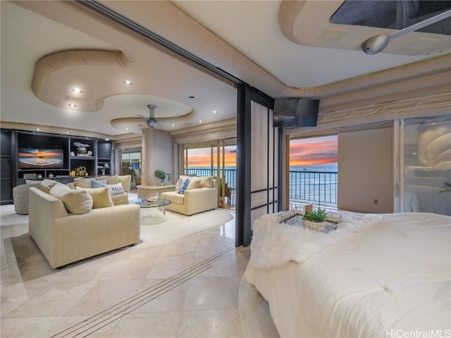 bedroom with access to exterior and a raised ceiling