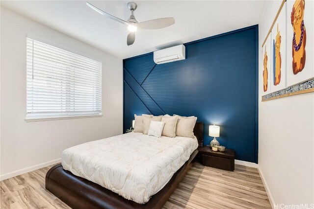 bedroom featuring ceiling fan, light hardwood / wood-style flooring, and a wall mounted AC