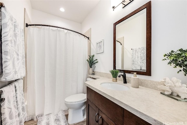 bathroom with hardwood / wood-style floors, vanity, and toilet