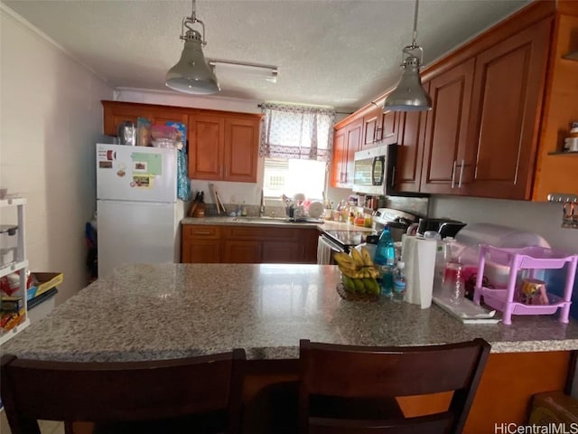 kitchen with a breakfast bar, decorative light fixtures, a textured ceiling, and stainless steel appliances