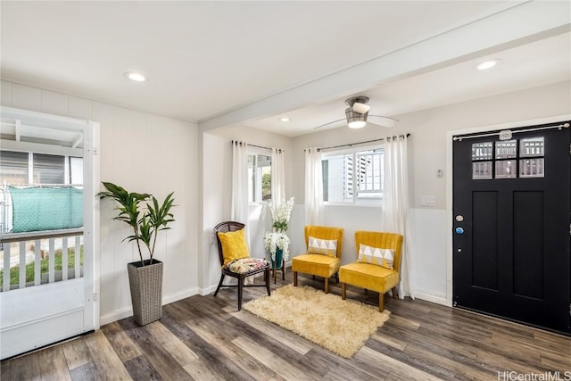 sitting room with dark wood-type flooring and ceiling fan