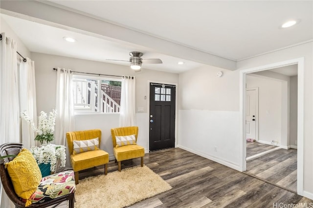 sitting room featuring dark wood-type flooring and beam ceiling