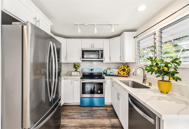 kitchen featuring sink, stainless steel appliances, white cabinets, and light stone countertops