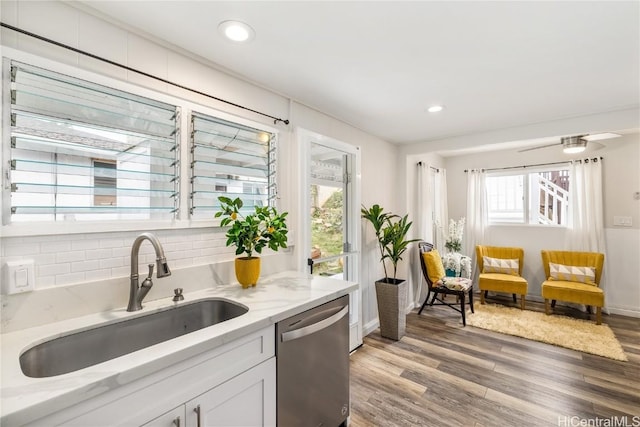 kitchen featuring sink, white cabinetry, tasteful backsplash, light wood-type flooring, and dishwasher