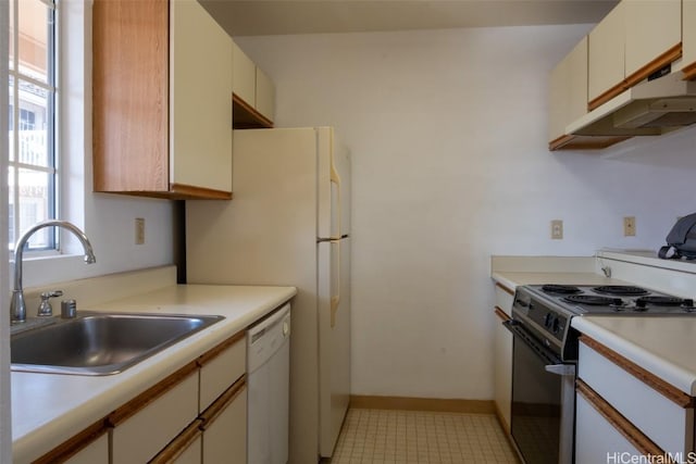 kitchen with stove, white dishwasher, and sink