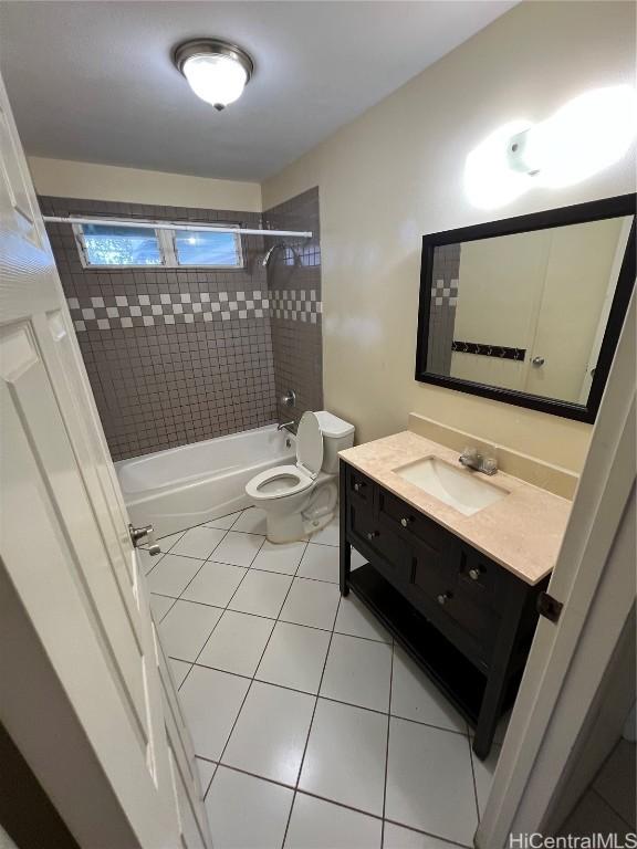 full bathroom featuring tiled shower / bath, tile patterned floors, toilet, and vanity