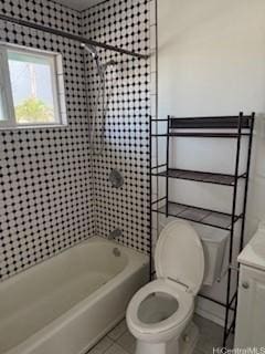 bathroom featuring tile patterned flooring, tiled shower / bath, and toilet