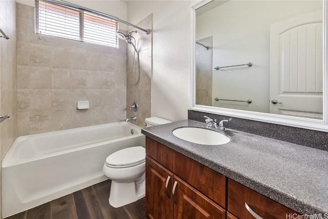 full bathroom featuring toilet, vanity, wood-type flooring, and tiled shower / bath