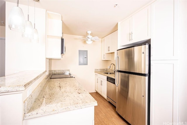 kitchen featuring stainless steel appliances, ceiling fan, decorative light fixtures, white cabinets, and light hardwood / wood-style floors