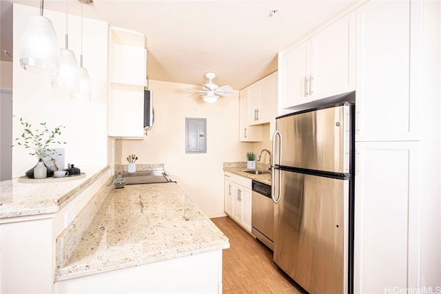 kitchen with appliances with stainless steel finishes, ceiling fan, pendant lighting, electric panel, and white cabinetry