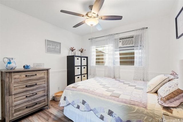 bedroom with wood-type flooring, an AC wall unit, and ceiling fan