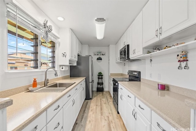 kitchen featuring white cabinetry, sink, stainless steel appliances, and light hardwood / wood-style floors