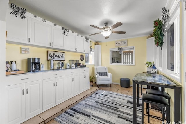 kitchen with white cabinetry, light tile patterned floors, and ceiling fan