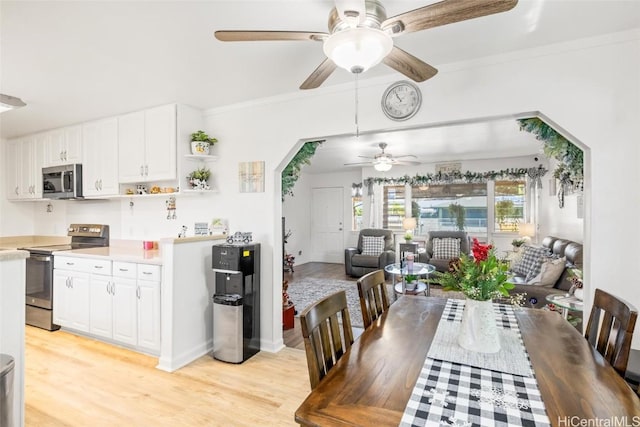 dining area with ceiling fan, light hardwood / wood-style floors, and ornamental molding