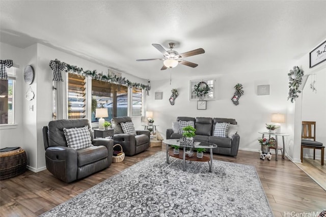 living room featuring ceiling fan and dark hardwood / wood-style flooring