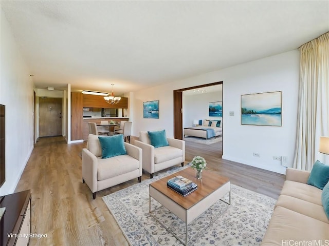 living room featuring light hardwood / wood-style flooring and an inviting chandelier