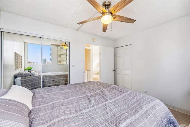 bedroom featuring a textured ceiling, carpet floors, and ceiling fan