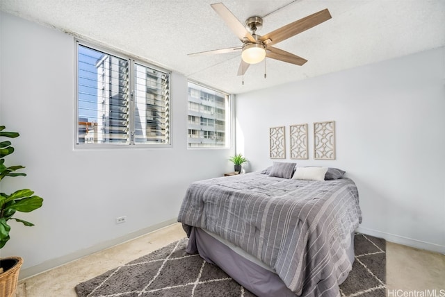 bedroom with carpet flooring, a textured ceiling, and ceiling fan